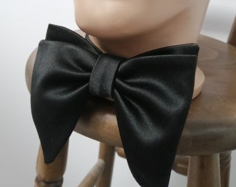 May include: A black satin bow tie. The bow tie is tied and ready to wear.