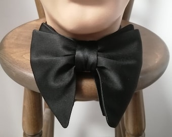 May include: A black satin bow tie with a pointed tip on each end.