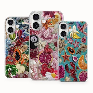 Pode incluir: Três capas de telefone decorativas com intrincados desenhos de contas. Uma capa apresenta uma lagosta, papaia e maçã. Outra mostra um morango, uma fatia de laranja e um oito. A terceira capa tem uma banana, uma estrela do mar e uma lagosta.