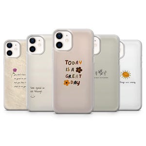 Pode incluir: Uma coleção de cinco capas de telemóvel com vários designs e citações. As capas apresentam uma gama de cores, incluindo bege, branco e verde. Uma capa tem o texto "Today is a great day". Outra diz "See good in all things".