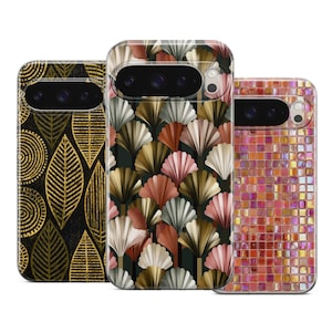 May include: Three smartphone cases featuring distinct patterns. The left case has gold leaf and circular motifs on a black background. The center case displays a fan-shaped design in shades of pink, gold, and white. The right case shows a grid of iridescent orange and pink square tiles.