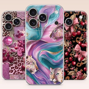 May include: Three smartphone cases featuring distinct designs. The left case displays a pink collage of cherries, leopard print, and a disco ball. The center case shows a teal and purple marble pattern with leopard heads. The right case features cherries and bows on a black leopard print background.