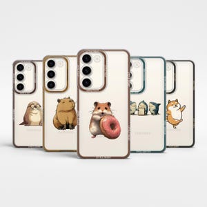 Puede incluir: Una colección de fundas transparentes para teléfonos con ilustraciones de animales. Los diseños incluyen un hámster con una rosquilla, un carpincho, una foca, tiburones y un Shiba Inu. Cada funda tiene un borde de color y el texto "LIFE IS GOOD", "LITTLE TREAT" y "STAY CURIOUS".