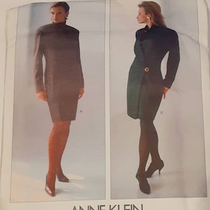 May include: Vogue Patterns sewing pattern for a dress by Anne Klein. The pattern includes two styles: a black dress with a high collar and a green dress with a wrap-style front.