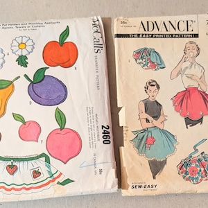 May include: Two vintage sewing pattern envelopes. The left envelope is a McCall's 2460 transfer pattern featuring colorful fruit and flower illustrations. The right envelope is an Advance 7751 sewing pattern showing illustrations of aprons.