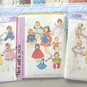 May include: Three vintage sewing pattern envelopes for baby doll clothing. Two identical Simplicity 7208 envelopes show illustrations of dolls in various outfits. One McCall's 3430 envelope features illustrations of dolls in diverse clothing and a carrier.