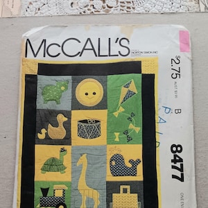May include: McCall's sewing pattern envelope featuring a colorful patchwork design with animal and toy illustrations. The pattern includes a frog, duck, turtle, giraffe, whale, and train. The text "Yours Truly for McCall's" is visible.