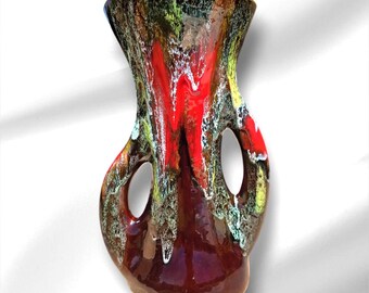 May include: A ceramic vase with a unique, organic shape. The vase features a vibrant color palette of red, brown, green, and yellow, with a glossy finish. It has two circular openings and a flared top, adding to its artistic appeal.