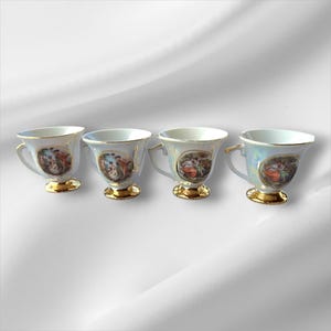 Puede incluir: Juego de cuatro tazas de té de porcelana blanca con ribetes dorados y un diseño floral pintado. Cada taza tiene un diseño floral diferente.