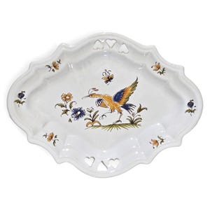 May include: An oval white ceramic serving tray with a scalloped edge and heart-shaped cutouts at the top and bottom. The center features a hand-painted illustration of a bird in flight with yellow and blue wings, surrounded by small floral motifs.