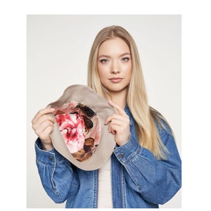 May include: A beige felt hat with a floral print lining. The hat is turned inside out to show the lining.