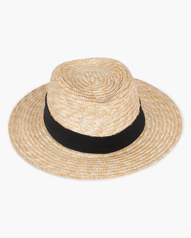 Puede incluir: Un sombrero de paja con una cinta negra. El sombrero es de color marr&oacute;n claro y tiene una textura tejida.