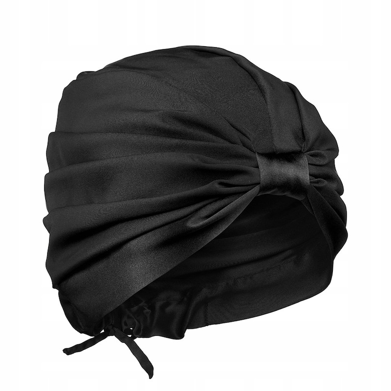 May include: A black satin turban with a bow on the top. The turban is designed to be worn as a hair wrap.