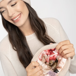 Puede incluir: Un gorro de cachemira beige con un forro de estampado floral. El gorro est&aacute; dado la vuelta para mostrar el forro.