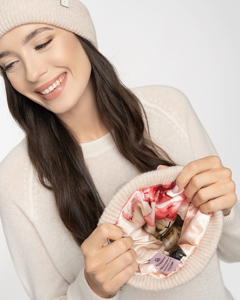 Puede incluir: Un gorro de cachemira beige con un forro de estampado floral. El gorro est&aacute; dado la vuelta para mostrar el forro.