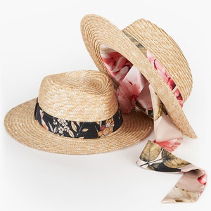 Puede incluir: Dos sombreros de paja con ribete de cinta floral. El sombrero de arriba tiene un forro floral rosa. El sombrero de abajo tiene una cinta floral negra.