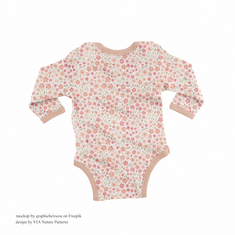 May include: A white baby onesie with a pink and green floral pattern. The onesie has long sleeves and a snap closure at the bottom.