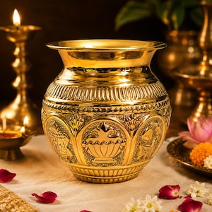 Pode incluir: Um vaso de latão polido com uma borda larga e um corpo arredondado decorado com painéis em relevo intrincados. A superfície exibe gravuras detalhadas de motivos tradicionais, incluindo desenhos florais e bordas geométricas, com um acabamento dourado reflexivo.