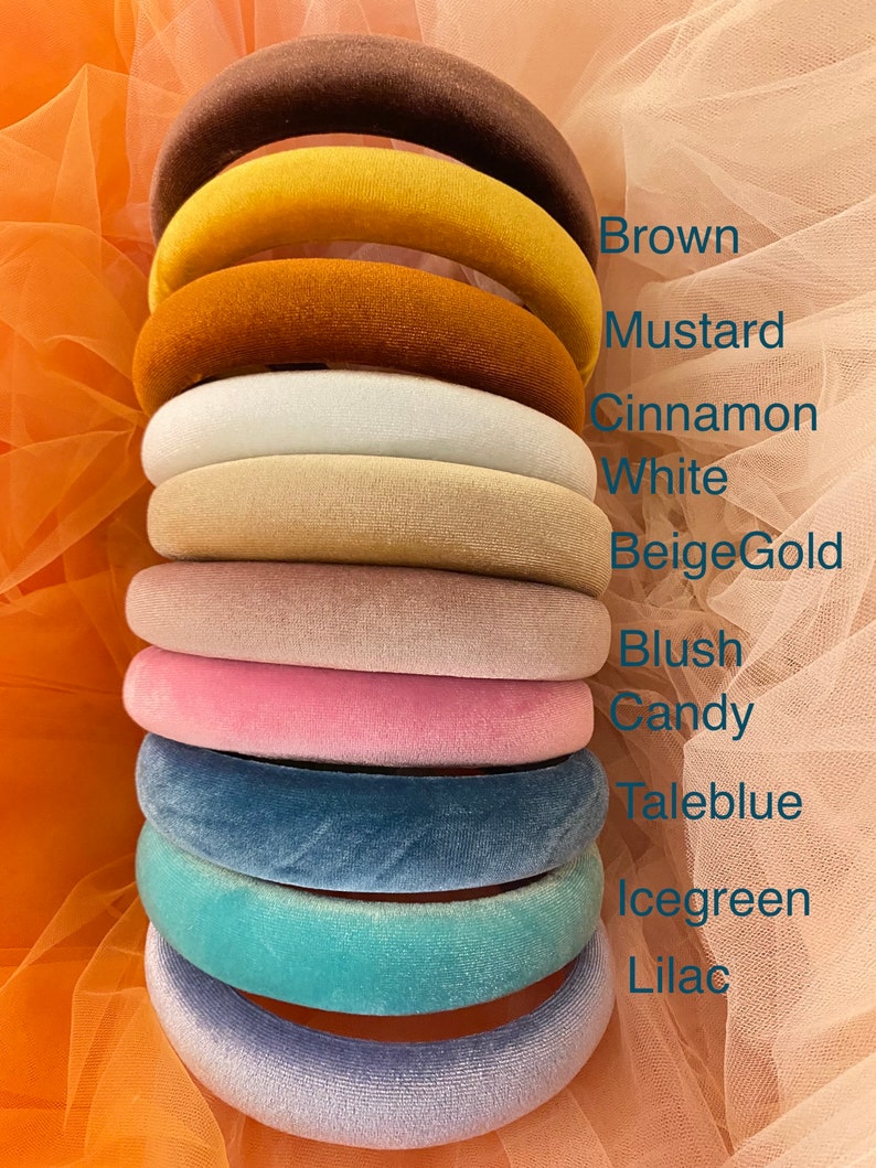 May include: A stack of velvet headbands in various colors, including brown, mustard, cinnamon, white, beige gold, blush, candy, taleblue, icegreen, and lilac. The names of the colors are listed in a column on the right side of the image.