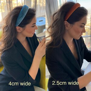 May include: Two images show a person wearing velvet headbands. One is teal, 4cm wide, and the other is rust-colored, 2.5cm wide. The headbands are a simple, padded design. The person is wearing a black blazer and has long, dark hair.