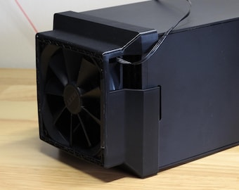 May include: A matte black computer case featuring a prominent square cooling fan mounted on the front panel. The fan has a central circular hub with the NZXT logo visible. A thin black power cable extends from the fan housing along the top.