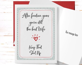 May include: A greeting card with a light blue background and white polka dots. The card has a red border and a red heart with a white outline. The text on the card reads "After fourteen years you're still the best Wife Keep That Shit Up".