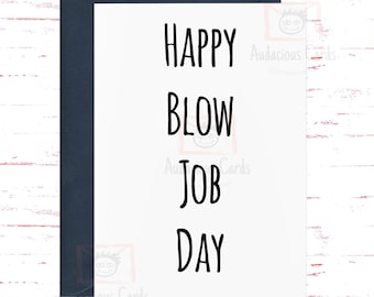 May include: A white greeting card with a navy blue envelope. The card displays the text "HAPPY BLOW JOB DAY" in a bold, black font. The background is a white surface with red and white wood grain.
