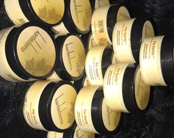 May include: A close-up of multiple jars of shea butter, labeled "Pur Karité" and "karitédiema". The jars are stacked on top of each other and are arranged in a circular pattern.