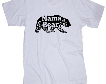 May include: White t-shirt with a black silhouette of a bear with the words "Mama Bear" inside the bear. The bear is filled with small floral and heart designs.