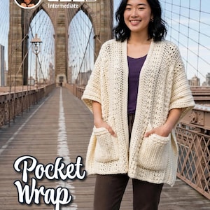 May include: An off-white, open-front crochet wrap featuring short sleeves, a textured stitch pattern, and two large front pockets. The garment is layered over a dark purple top and dark brown trousers. Text on the image reads "Crochet with Phyllis" and "Pocket Wrap".