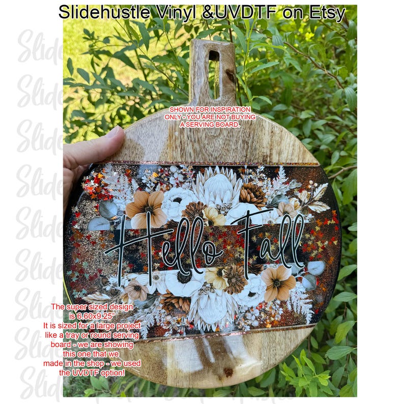 May include: A wooden serving board with a handle, featuring a floral design and the words "Hello Fall." The design includes white, brown, and orange flowers, with glitter accents. The board measures 6.60 x 9.25 inches.