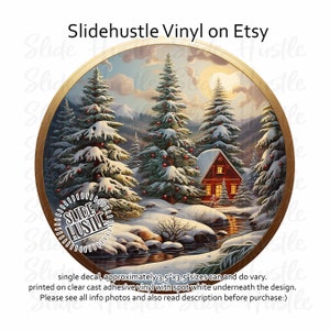 May include: A round vinyl decal featuring a winter scene with a small red cabin nestled in a snowy forest. The decal is approximately 3.5 inches by 3.5 inches and is printed on clear cast adhesive vinyl with a spot of white underneath the design.