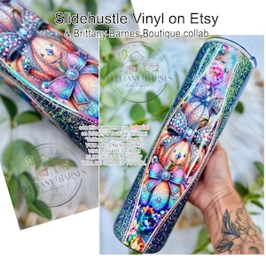 May include: A glittery tumbler with a colorful pumpkin design and bow accents. The text "Slidehustle Vinyl on Etsy & Brittany Barnes Boutique collab" is visible. The tumbler is decorated with floral and glitter details. The text "see this awesome cup tutorial on Brittany's Youtube channel" is also visible.
