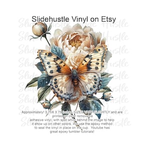 May include: A digital design featuring a butterfly with brown, orange, and blue wings, perched on a white flower with green leaves. The design is approximately 3.75 inches by 3.75 inches and is printed on clear removable adhesive vinyl. The text "Slidehustle Vinyl on Etsy" is visible in the background.