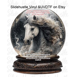 May include: A decorative snow globe featuring a white horse with flowing mane and a detailed wooden base. The globe has a dark, starry background. Text on the image reads "Slidehustle Vinyl & UVDTF on Etsy" and "UVDTF Decal - sized at just under 4".