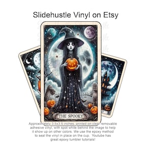 May include: Three Halloween-themed vinyl stickers. The central sticker features a witch holding a pumpkin in front of a full moon. The text "THE SPOOKY" is at the bottom. The stickers are approximately 3.5 x 3.5 inches.