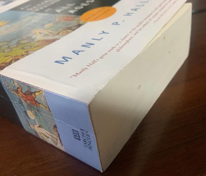 Pode incluir: Um livro de capa dura intitulado "The Western World in the Middle Ages" de Manly P. Hall. A capa do livro apresenta uma ilustra&ccedil;&atilde;o colorida de pessoas com roupas medievais.
