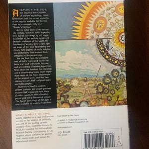 Pode incluir: A contracapa de um livro de bolso intitulado "The Secret Teachings of All Ages" de Manly P. Hall. A capa apresenta uma ilustra&ccedil;&atilde;o colorida de uma f&ecirc;nix que surge das chamas, cercada por um sol com uma aur&eacute;ola radiante de luz. O livro &eacute; um cl&aacute;ssico desde 1928 e &eacute; uma enciclop&eacute;dia completa de mitologia antiga, rituais, simbolismo e mist&eacute;rios arcanos.
