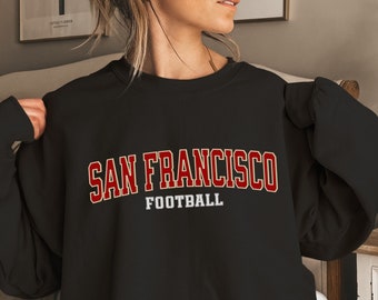 May include: Black sweatshirt with red and white text that reads "SAN FRANCISCO FOOTBALL"