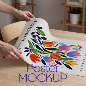 Puede incluir: Una maqueta de póster con un diseño floral colorido, que presenta tulipanes en tonos rojos, naranjas y azules. El póster tiene las palabras "Amsterdam" y "Flower Market". Las palabras "Poster Mockup" también son visibles.