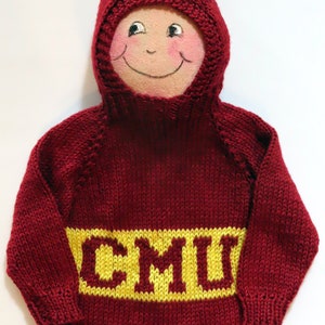 May include: A red knitted sweater with a yellow knitted band across the chest that says "CMII". The sweater has a matching red knitted hood.
