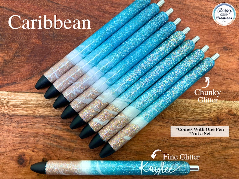 Puede incluir: Un conjunto de ocho bol&iacute;grafos con tem&aacute;tica caribe&ntilde;a. Los bol&iacute;grafos tienen un dise&ntilde;o de purpurina azul y blanca con un acento de purpurina dorada. Los bol&iacute;grafos est&aacute;n etiquetados como "Caribe" y "Purpurina gruesa".