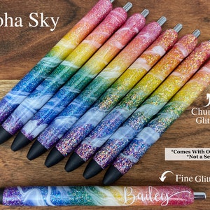 Puede incluir: Un conjunto de bol&iacute;grafos de purpurina arco&iacute;ris con un dise&ntilde;o de remolino blanco. Los bol&iacute;grafos tienen una opci&oacute;n de purpurina gruesa y purpurina fina. El texto "Aloha Sky" y "Glossy Cup Creations Co." es visible en la imagen. El texto "Chunky Glitter", "Fine Glitter" y "*Comes With One Pen *Not a Set" tambi&eacute;n es visible en la imagen.