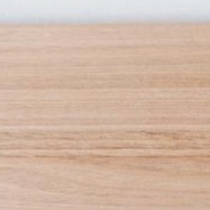 K&ouml;nnte beinhalten: Nahaufnahme einer hellbraunen Holzplatte mit zwei vorgebohrten L&ouml;chern zum Aufh&auml;ngen.