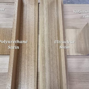 May include: Image showcasing variations in raw timber with two samples. One is treated with Polyurethane Satin, displaying a warm, medium brown hue. The other is treated with Ultraclear Satin, exhibiting a lighter, natural wood tone.