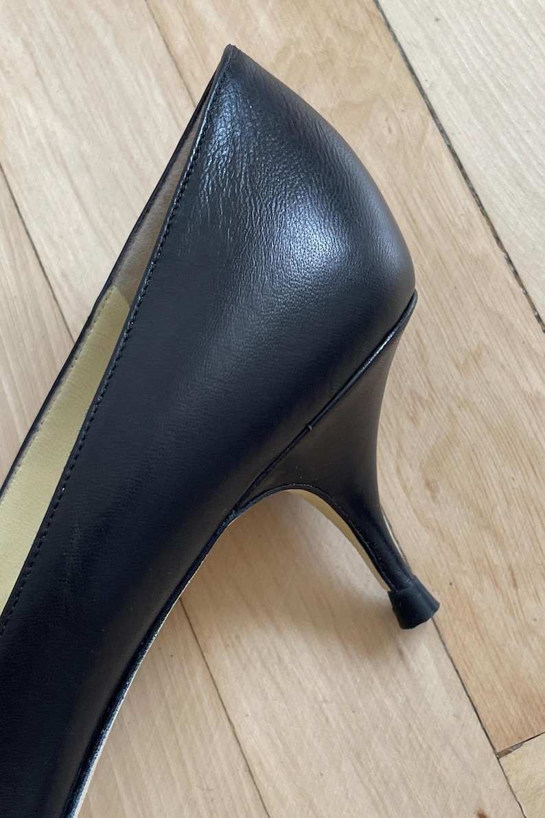 K&ouml;nnte beinhalten: Schwarzer Lederschuh mit Absatz, spitzem Zeh und niedrigem Absatz.