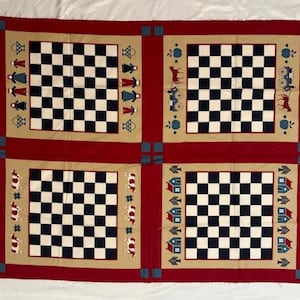 May include: A red and tan quilt featuring four squares with black and white checkerboard patterns. Each square is bordered by tan fabric with decorative elements like people, cows, houses, and carriages. The quilt has a red border.