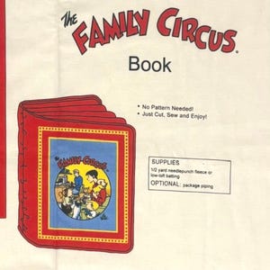 May include: A fabric panel for a The Family Circus book project. The off-white fabric features red text, instructions, and a graphic of a red-bound book with a circular illustration of the cartoon family. Supplies listed include 1/2 yard fleece.