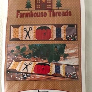 May include: A pattern for a quilted table runner called "My Sewing Box Mini Runner" by Farmhouse Threads. The runner is 6.5 inches by 28 inches and features a red sewing box, scissors, and buttons.