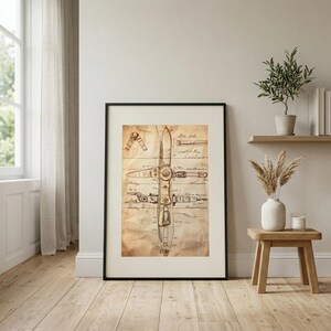 May include: Framed vintage blueprint of a mechanical device, possibly a propeller. The artwork features detailed line drawings and handwritten notes on aged, textured paper, set within a black frame. The color palette is primarily sepia tones, evoking a sense of history.